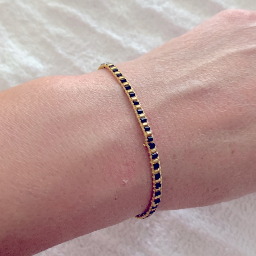 Black and gold beaded friendship bracelet with adjustable string closure